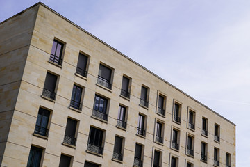 modern brown corner of new building with many windows against sky