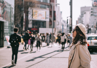Asian girl standing out from the crowd at a city street in Japan.