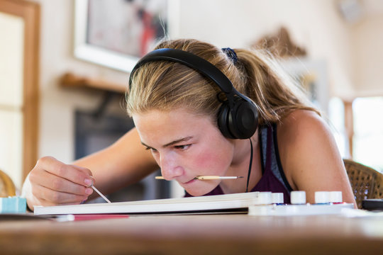 Close up view of girl painting while wearing headphones