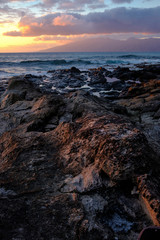 Fototapeta na wymiar Volcanic Rocks at the Shore During Sunset