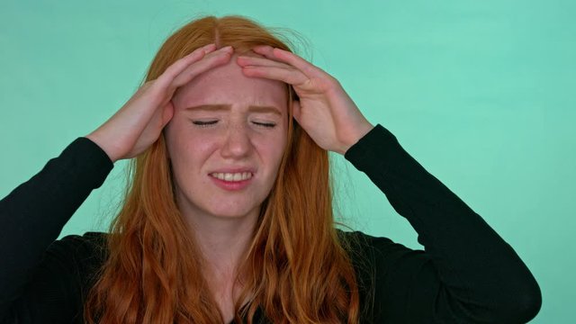 lady in black sweatshirt holding her head, still medium close up shot