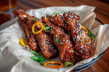 Gourmet Baked Chicken Wings with Barbecue Sauce and Salt and Pepper Seasoning with Greens and Sliced Peppers