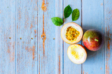 Fresh Tropical Passion Fruits on blue wooden table in top view flat lay with copy space for background or wallpaper. Ripe passion fruit so sweet and sour. Tropical fruit.