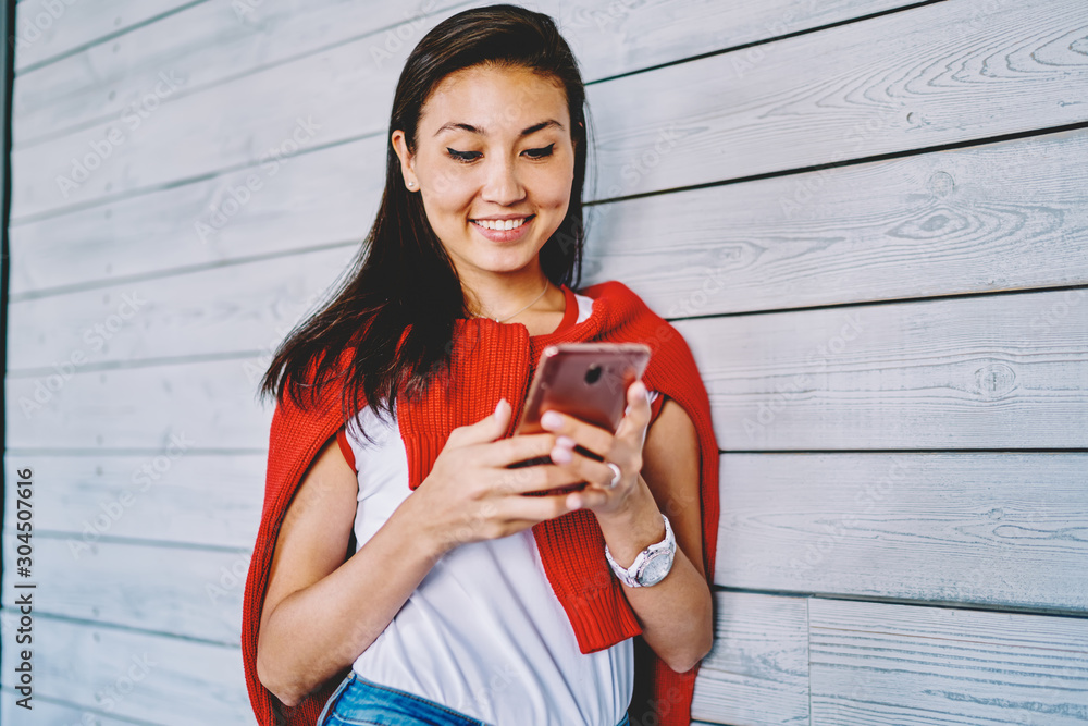 Poster happy cheerful chinese woman updating profile in social network downloading media file via applicati