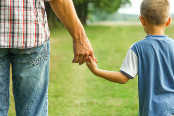 the parent holds the hand of a l child