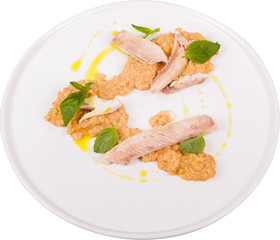 Rice topped with basil and fish on white plate.