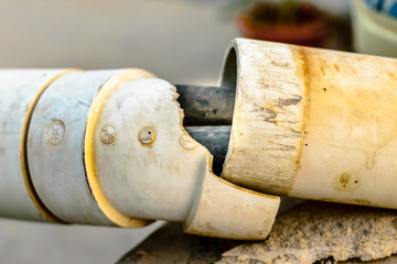 closeup of a broken PVC pipe that was to protect power supply cables inside it