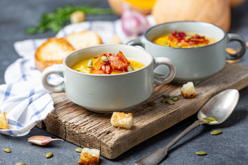 Pumpkin soup with bacon in a rustic style.