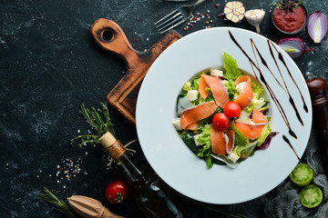 Vegetable salad with salted salmon and cherry tomatoes. Caesar salad with salmon. Top view. Free space for your text.