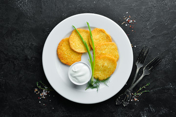 Potato pancakes with sour cream and onions. Top view. Free space for your text.