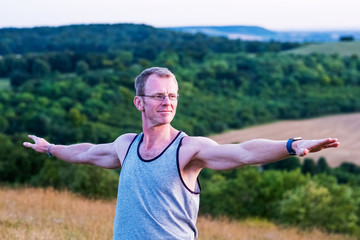 Selective focus of man taking part in yoga class on hillside