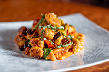 Homemade Italian Gnocchi with red tomato sauce, cheese, red peppers and fresh basil