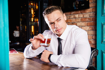Businessman drinks whiskey at the bar