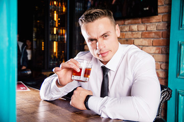 Businessman drinks whiskey at the bar