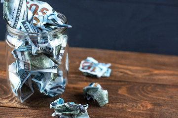 crumpled dollars in a glass jar