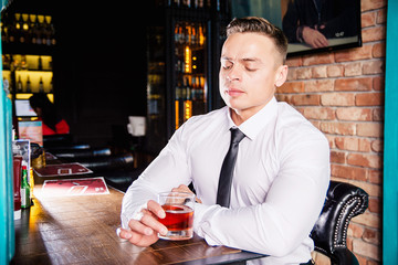 Businessman drinks whiskey at the bar