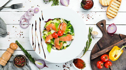 Vegetable salad with salted salmon and cherry tomatoes. Caesar salad with salmon. Top view. Free...