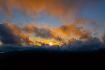 sunset mountain sky blue colorful autumn sun light yellow orange clouds tree smoke fog haze