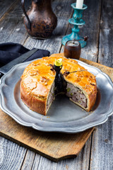 Traditional French Pate en croute with goose meat and liver as closeup on a pewter plate