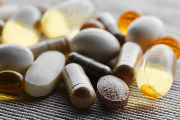 Close-up of dietary supplements, pills, vitamins and medicines on tissue background