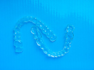 Invisible dental aligners, teeth brackets on blue background, Plastic braces dentistry retainers to...