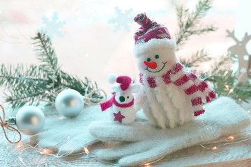 Toy snowman, rat, Christmas decor, illumination on a wooden surface on a window background, decorating the interior for winter seasonal holidays