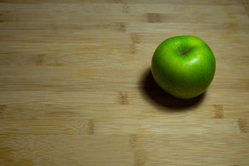 Fresh green apple on a wooden table, top view