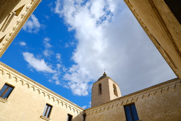 Convent of Sant'Agostino in Matera. Beige stone facade with blue sky and clouds.