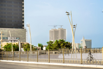 less traffic flow in a modern city in the morning with beautiful sunshine and palm trees in the middle on the road