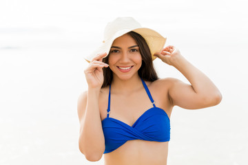 Smiling Female Posing With Hat At Beach