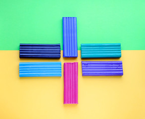 Multi-colored plasticine on a yellow and green background