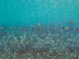 Fototapeta na wymiar Stony bottom under greenish transparent water. Thailand 
