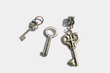 Three metal decorative keys of different shapes on a white background