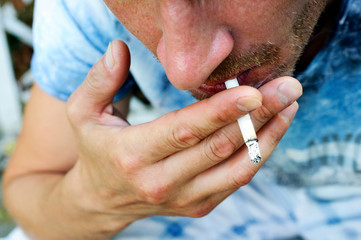 Close up young man smoking a cigarette.