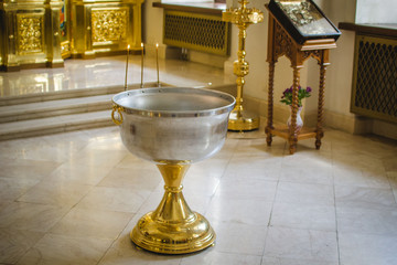 The Holy Orthodox rite of the sacrament of baptism newborn baby in a small wooden Christian Church...