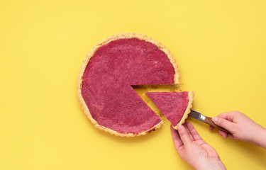 Obraz na płótnie Canvas Slicing a cranberry pie. Taking a piece of cranberry tart.
