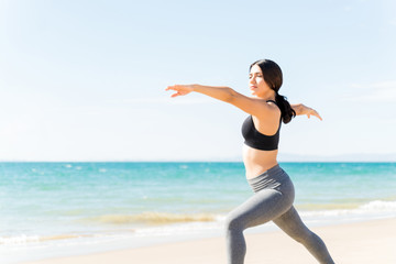 Woman Stretching Arms While Exercising At Beach