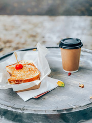 Sandwich on paper with coffee. Street food concept