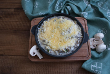mushroom julienne frying pan on a wooden table