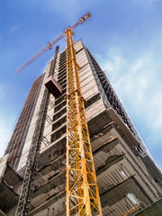 bottom view of an under construction building with blue sky in background 