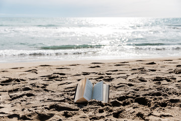 libro clásico abierto en el suelo, en la arena de la playa.