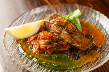Close up of chum salmon marinated in lemon juice with stewed vegetables on wooden table