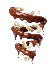 Chocolate splashes in spiral shape with crushed cashew nuts, isolated on a white background