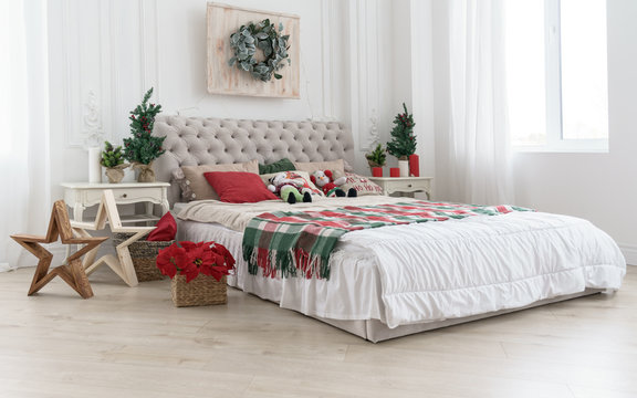 Decorated bedroom for Christmas holidays with trees and flowers in white room