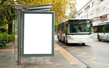 White blank vertical billboard at the bus stop on the city street. In the background of buses and roads. Sketch. Poster on the street next to the road.