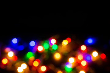 Christmas lights are lit on a black background. Copy the area for the top view text.