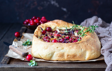 Homemade open pie with different types of cabbage, sauerkraut and cranberry on wooden tray. Selective focus, rustic style. Vegetarian food.