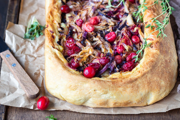 Homemade open pie with different types of cabbage, sauerkraut and cranberry on wooden tray. Selective focus, rustic style. Vegetarian food.