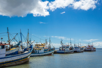 Fototapeta na wymiar Cargo and pleasure boats moored at pier in Rio Grande canal in southern Brazil