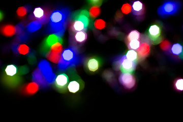 Christmas lights are lit on a black background. Copy the area for the top view text.